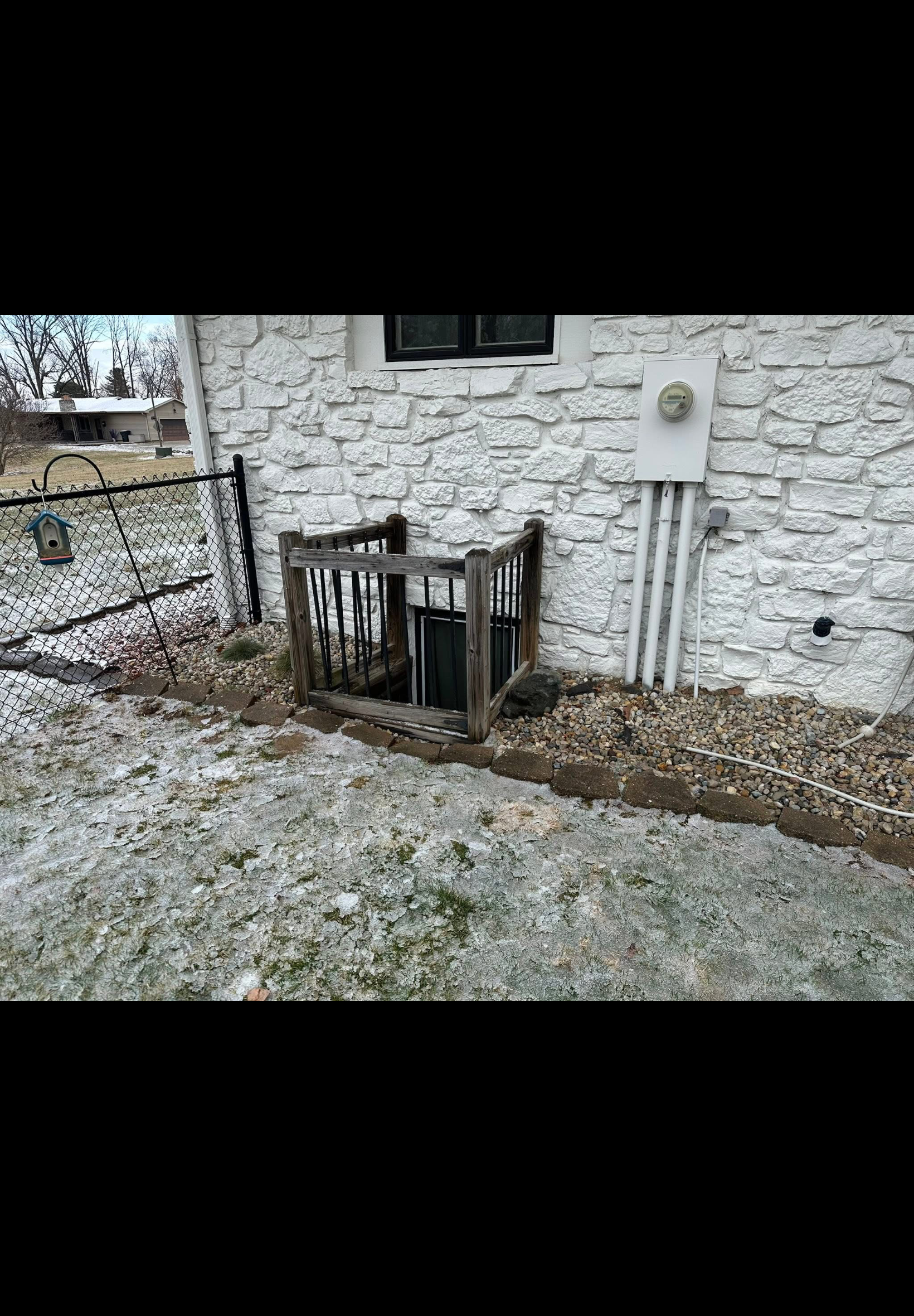 Old deteriorated window well enclosure before replacement